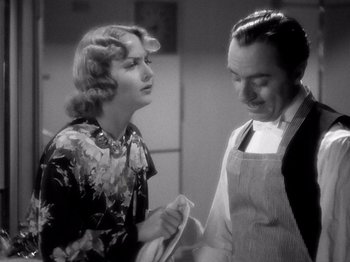 Movie still from “My Man Godfrey” (1936), directed by Gregory La Cava – An old photo of a man and a woman in a kitchen; Medium shot, Over the shoulder angle