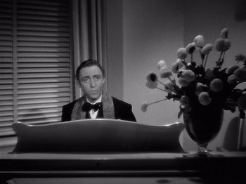 Movie still from “My Man Godfrey” (1936), directed by Gregory La Cava – A black and white photo of a man sitting at a desk; Medium shot, High angle