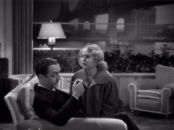 Movie still from “My Man Godfrey” (1936), directed by Gregory La Cava – A man and a woman sitting on a couch in front of a window; Medium shot, High angle
