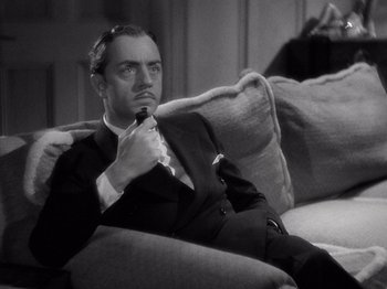 Movie still from “My Man Godfrey” (1936), directed by Gregory La Cava – A black and white photo of a man sitting on a couch; Close Up shot, High angle