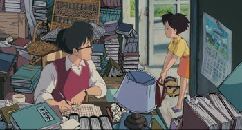 Movie still from “My Neighbor Totoro” (1988), directed by Hayao Miyazaki – An animated scene of a man and a little girl in a room; Medium shot, High angle