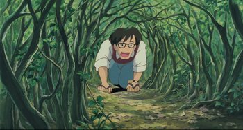 Movie still from “My Neighbor Totoro” (1988), directed by Hayao Miyazaki – An animated picture of a man in the woods; Wide shot, High angle