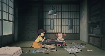 Movie still from “My Neighbor Totoro” (1988), directed by Hayao Miyazaki – Two children sitting on the floor in a room; Wide shot, High angle