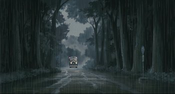 Movie still from “My Neighbor Totoro” (1988), directed by Hayao Miyazaki – A bus driving down a road in the rain; Extreme Wide shot, Low angle