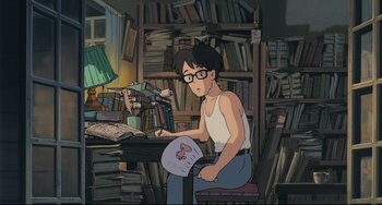 Movie still from “My Neighbor Totoro” (1988), directed by Hayao Miyazaki – An animated man sitting in front of a book shelf; Wide shot, High angle