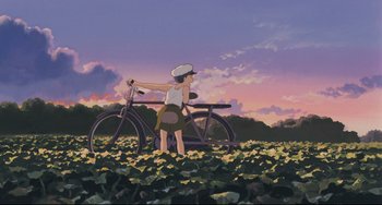 Movie still from “My Neighbor Totoro” (1988), directed by Hayao Miyazaki – A woman standing next to a bike in a field; Wide shot, Low angle
