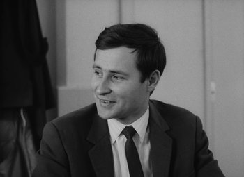 Movie still from “My Night at Maud's” (1969), directed by Éric Rohmer – Black and white photograph of a man in a suit; Close Up shot, Low angle