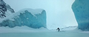 Movie still from “Mystery, Alaska” (1999), directed by Jay Roach – A person is skiing in the middle of a snowy field; Extreme Wide shot, Low angle