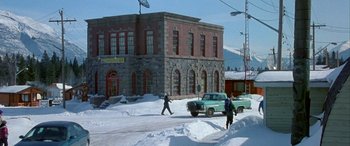 Movie still from “Mystery, Alaska” (1999), directed by Jay Roach – A group of people walking across a snow covered street; Extreme Wide shot, High angle