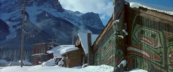 Movie still from “Mystery, Alaska” (1999), directed by Jay Roach – A man riding skis on top of a snow covered slope; Extreme Wide shot, High angle