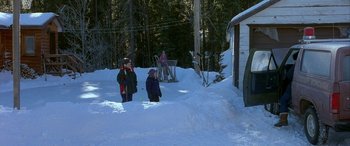 Movie still from “Mystery, Alaska” (1999), directed by Jay Roach – A group of people standing on top of a snow covered ground; Extreme Wide shot, High angle