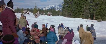 Movie still from “Mystery, Alaska” (1999), directed by Jay Roach – A group of people standing on top of a snow covered slope; Extreme Wide shot, High angle