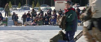 Movie still from “Mystery, Alaska” (1999), directed by Jay Roach – A person standing in the middle of a snow covered field; Wide shot, High angle
