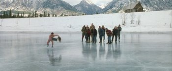 Movie still from “Mystery, Alaska” (1999), directed by Jay Roach – A group of people standing on top of an ice rink; Extreme Wide shot, High angle