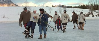 Movie still from “Mystery, Alaska” (1999), directed by Jay Roach – A group of people on a field playing hockey; Wide shot, High angle