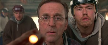 Movie still from “Mystery, Alaska” (1999), directed by Jay Roach – An older man wearing glasses looking at the camera; Close Up shot, Low angle