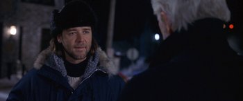 Movie still from “Mystery, Alaska” (1999), directed by Jay Roach – A man wearing a winter coat and hat talking to another man; Close Up shot, Over the shoulder angle