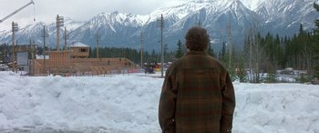 Movie still from “Mystery, Alaska” (1999), directed by Jay Roach – An older man standing in the snow looking at the mountains; Extreme Wide shot, High angle