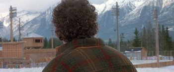 Movie still from “Mystery, Alaska” (1999), directed by Jay Roach – A man with curly hair is wearing a plaid jacket; Close Up shot, Over the shoulder angle