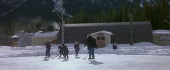 Movie still from “Mystery, Alaska” (1999), directed by Jay Roach – A group of skiers are standing in the snow; Extreme Wide shot, High angle