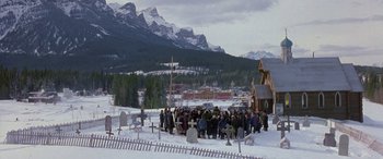 Movie still from “Mystery, Alaska” (1999), directed by Jay Roach – A group of people standing in the middle of a snowy field; Extreme Wide shot, High angle