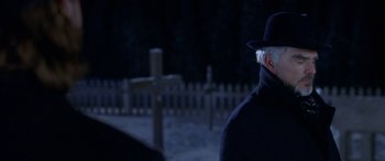 Movie still from “Mystery, Alaska” (1999), directed by Jay Roach – A man wearing a hat and a black coat; Close Up shot, Over the shoulder angle