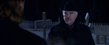 Movie still from “Mystery, Alaska” (1999), directed by Jay Roach – An older man wearing a black hat and a black coat; Close Up shot, Over the shoulder angle