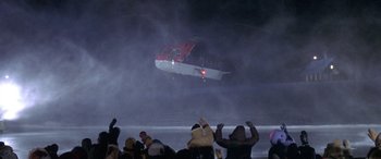 Movie still from “Mystery, Alaska” (1999), directed by Jay Roach – A crowd of people standing around a helicopter in the air; Extreme Wide shot, High angle