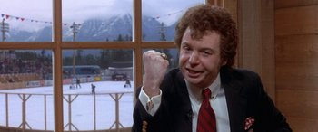 Movie still from “Mystery, Alaska” (1999), directed by Jay Roach – A man in a suit and red tie holding up his fist; Close Up shot, Low angle