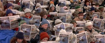 Movie still from “Mystery, Alaska” (1999), directed by Jay Roach – A group of people sitting down reading newspapers; Medium shot, High angle