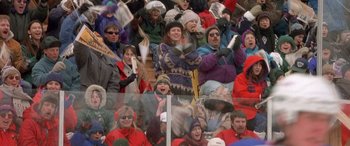 Movie still from “Mystery, Alaska” (1999), directed by Jay Roach – A group of people sitting in the stands at a sporting event; Wide shot, High angle