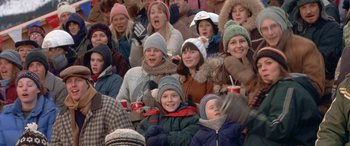 Movie still from “Mystery, Alaska” (1999), directed by Jay Roach – A group of people sitting in a crowd wearing winter hats; Medium shot, High angle
