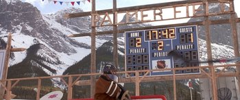 Movie still from “Mystery, Alaska” (1999), directed by Jay Roach – A hockey player is standing in front of a scoreboard; Extreme Wide shot, Low angle