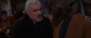 Movie still from “Mystery, Alaska” (1999), directed by Jay Roach – A man in a suit talking to another man in a suit; Close Up shot, Over the shoulder angle