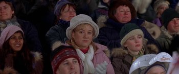 Movie still from “Mystery, Alaska” (1999), directed by Jay Roach – A group of people sitting in a crowd wearing winter clothing; Close Up shot, High angle