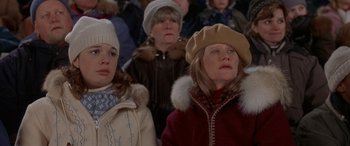 Movie still from “Mystery, Alaska” (1999), directed by Jay Roach – A group of people standing next to each other in a room; Medium shot, High angle