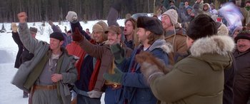 Movie still from “Mystery, Alaska” (1999), directed by Jay Roach – A group of men standing next to each other in the snow; Medium shot, High angle