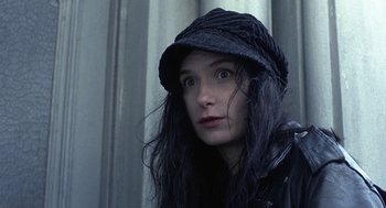Movie still from “Naked” (1993), directed by Mike Leigh – A woman wearing a black hat and a black jacket; Close Up shot, High angle