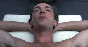 Movie still from “Naked” (1993), directed by Mike Leigh – A person laying on their stomach; Close Up shot, Overhead angle