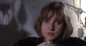Movie still from “Naked” (1993), directed by Mike Leigh – A person holding a cigarette in her mouth; Close Up shot, Over the shoulder angle