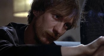 Movie still from “Naked” (1993), directed by Mike Leigh – A person with long hair and a beard; Close Up shot, Over the shoulder angle
