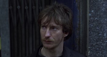 Movie still from “Naked” (1993), directed by Mike Leigh – A person with a beard; Close Up shot, Over the shoulder angle