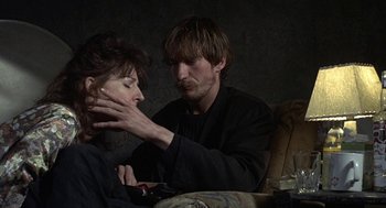 Movie still from “Naked” (1993), directed by Mike Leigh – A man and a woman sitting on a couch looking at each other; Close Up shot, Over the shoulder angle