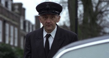 Movie still from “Naked” (1993), directed by Mike Leigh – An older man in a suit and a hat; Close Up shot, Low angle