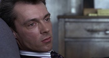 Movie still from “Naked” (1993), directed by Mike Leigh – A person wearing a suit and tie; Close Up shot, Over the shoulder angle
