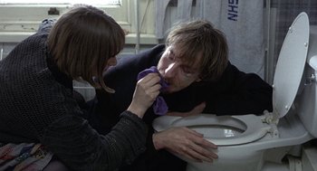 Movie still from “Naked” (1993), directed by Mike Leigh – A man and a woman in a bathroom with a toilet; Medium shot, High angle