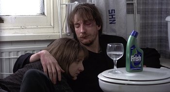 Movie still from “Naked” (1993), directed by Mike Leigh – A man and a woman sitting next to each other at a dinner table; Close Up shot, High angle