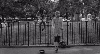 Movie still from “Frances Ha” (2012), directed by Noah Baumbach – Two women are hanging from a fence in a park; Wide shot, Over the shoulder angle