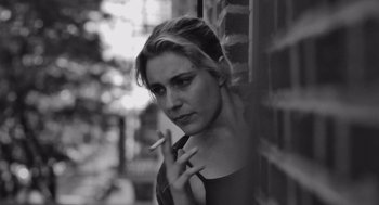 Movie still from “Frances Ha” (2012), directed by Noah Baumbach – A black - and - white photo of a woman smoking a cigarette; Close Up shot, Low angle