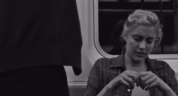 Movie still from “Frances Ha” (2012), directed by Noah Baumbach – A woman sitting on a train looking at her cell phone; Close Up shot, Over the shoulder angle